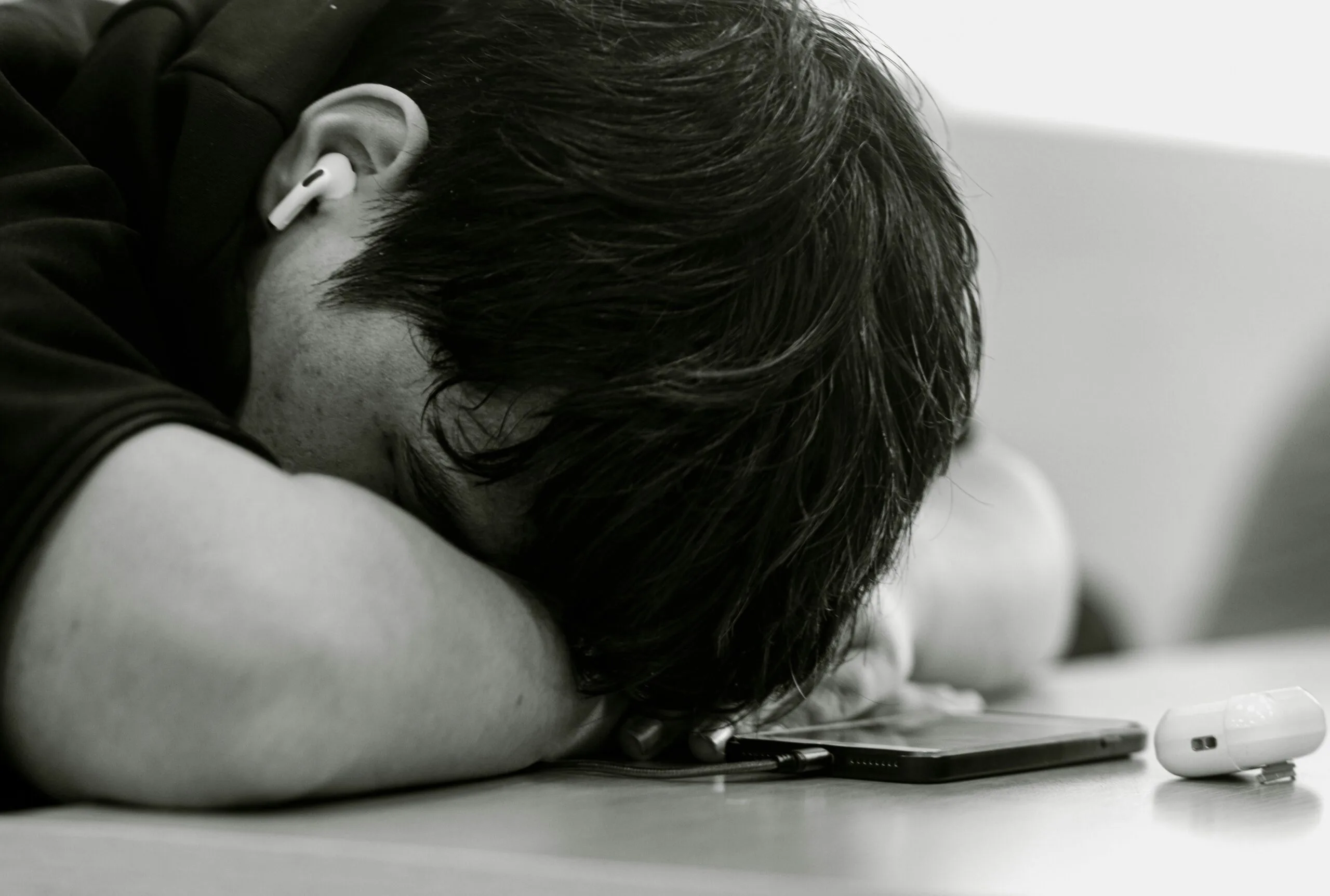 A man laying his head on his cell phone